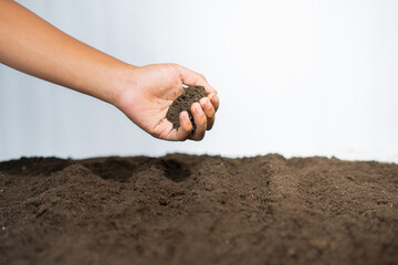 Hand holding soil with background of farm field ready to planting