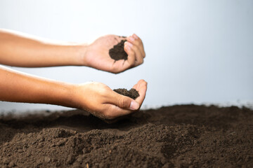 Two hands holding fertile soil for quality comparison