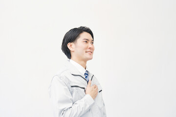 胸に手を置く作業着の男性のポートレート　白背景