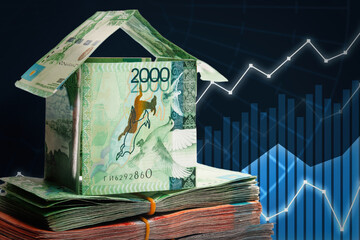 House made of banknotes of Kazakh money stands on packs of tenge. Real estate price growth concept.