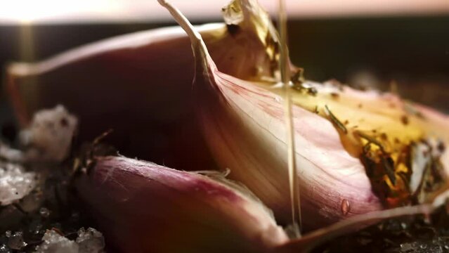 macro shot of garlic in apan, with salt and olive oil in slow motion