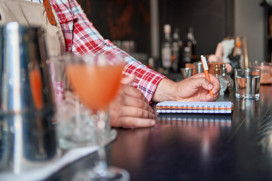 bartender standing at bar counter taking notes