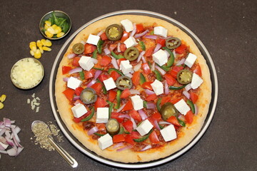 Indian pizza with vegetables like Paneer, Onion, Paprika 