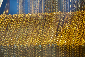 Close up of the jewelry gold necklaces ring, chains  show in  beauty retail store window display...