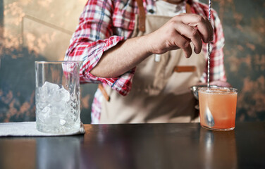 bartender mixing a cocktail at the bar.