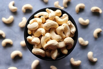Tasty Cashew nuts in a mini wooden bowl on the background. Goan Kaju. Copy space. Dry fruits background or festival banners. Diwali gifting concept.