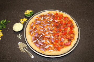 Pizza in a pan with onion and tomato 