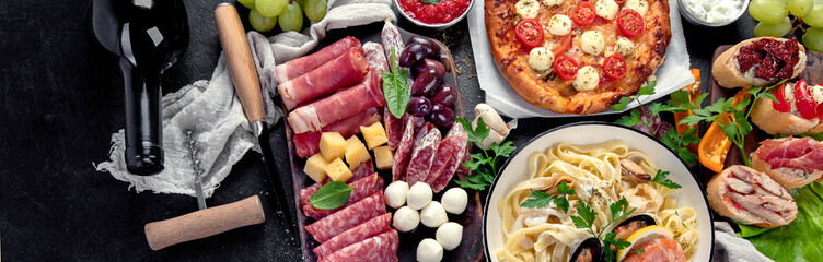 Italian food dishes on dark background.