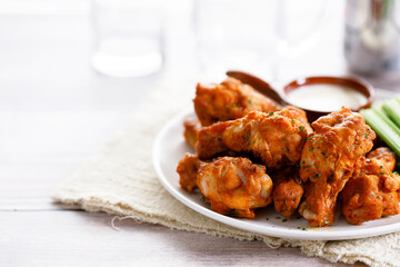 Barbecue chicken wings on a white plate.