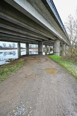 Autobahnbrücke von unten mit Betonpfeiler und Spiegelung im Wasser des Hochwassers, bei Schweinfurt