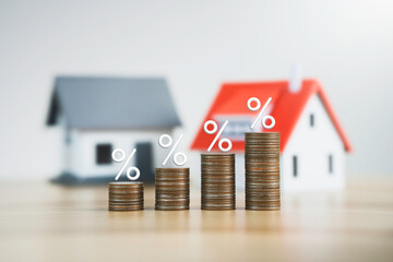 the percentage symbol for increasing interest rates on stacks of coins and the model house. Interest rates increase, home loan, mortgage, house tax. investment and asset management concept - obrazy, fototapety, plakaty