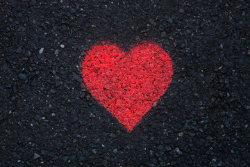 Lovley red heart as a graffiti on black street background
Heart symbol for love, valentines day or wedding, 
table top view