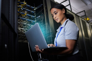 Fototapeta na wymiar Laptop, network and data center with a black woman it support engineer working in a dark server room. Computer, cybersecurity and analytics with a female programmer problem solving or troubleshooting