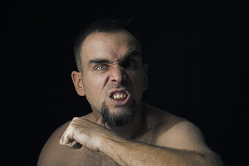 A man with an angry expression on his face, a man threatening with his thumb at his throat....