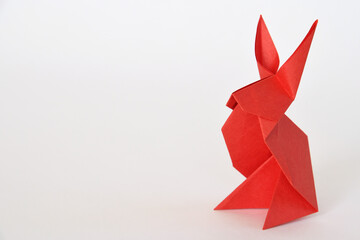 Red origami paper rabbit on white background.