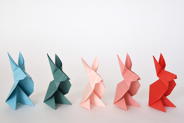 Origami paper rabbits on white background.