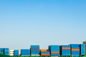 A large cargo container ship loaded with containers against the blue sky and empty space