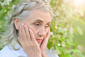 sad old nice beautiful woman in park