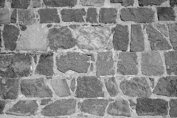 A close-up of a stone wall in black and white