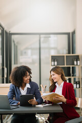 Obraz premium Two businesswoman discuss investment project working and planning strategy with tablet laptop computer in modern office..
