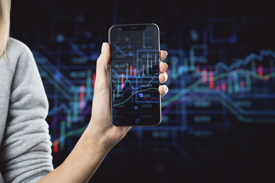 Stock market growth and online investing concept with modern smartphone screen with growing up financial chart candlestick in woman hand on blurred digital wall background with forex indicators