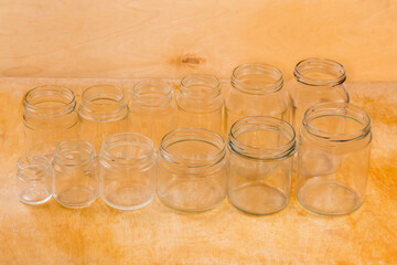 Empty glass jars different sizes on a wooden surface
