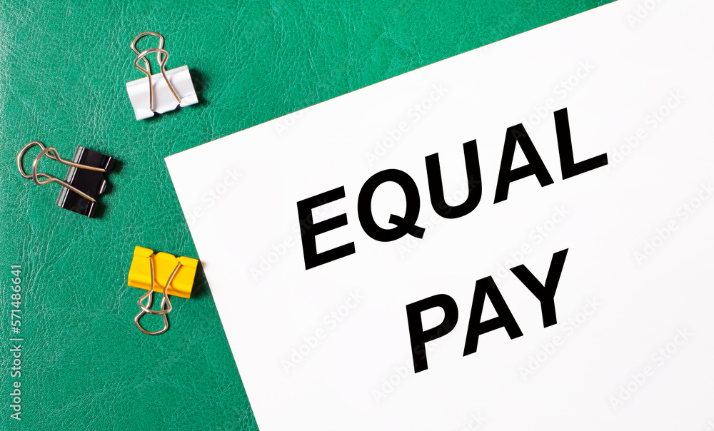 Poster multi-colored paper clips and a sheet of paper with the text equal pay on a green notepad.