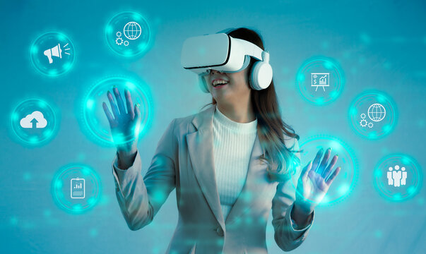 Business technology concept. Businesswoman wearing VR headset watching and touching icon on world virtual data and entertainment. blurred green color background. - Powered by Adobe