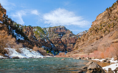 wait to see if photoshop version excepted!!!
Beautiful view of river floating through canyon in winter; fast running water in foreground; mountains and blue sky in background; distant view of highway 