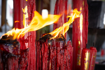 Close-up of the flames from the Chinese candles at the Buddha shrine in a Chinese temple located in Thailand.