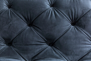 Naklejka premium Quilted blue velor sofa or bed back. A modern classic in interior decoration. Front view. Close-up. Background. Space for text.