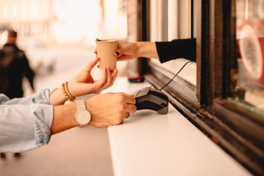 Customer making payment with credit card buying coffee on city street