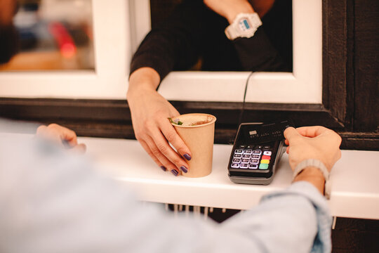 Customer making payment with credit card buying coffee at stall