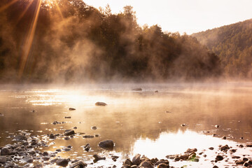 Warmy beautiful morning summer landscape with mist on river with  golden fluffy haze, ripple of sun...