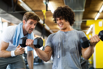 Fit man working out in gym with personal trainer to stay healthy. Sport, people concept