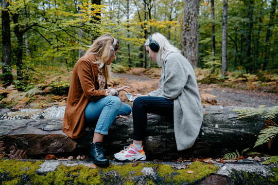 Two young adult watching a video on a smartphone in a remote forest