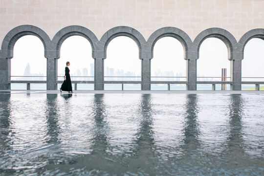 Young woman walking by the pool in Museum of Islamic art in Doha