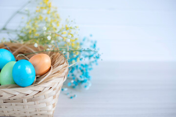 Happy Easter. Congratulatory easter background. Easter eggs and flowerson white table.