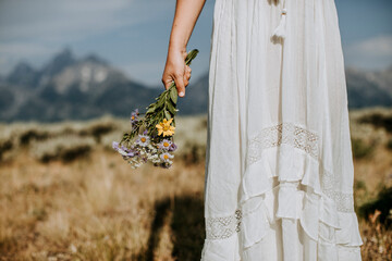 close up of bride with wildflower bouquet in front of Tetons, Wyoming