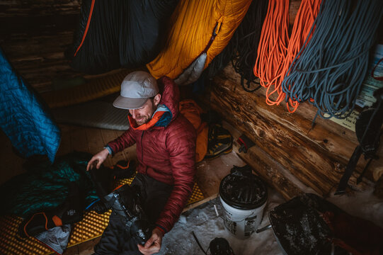 Man taking liner out of ski boot in backcountry cabin
