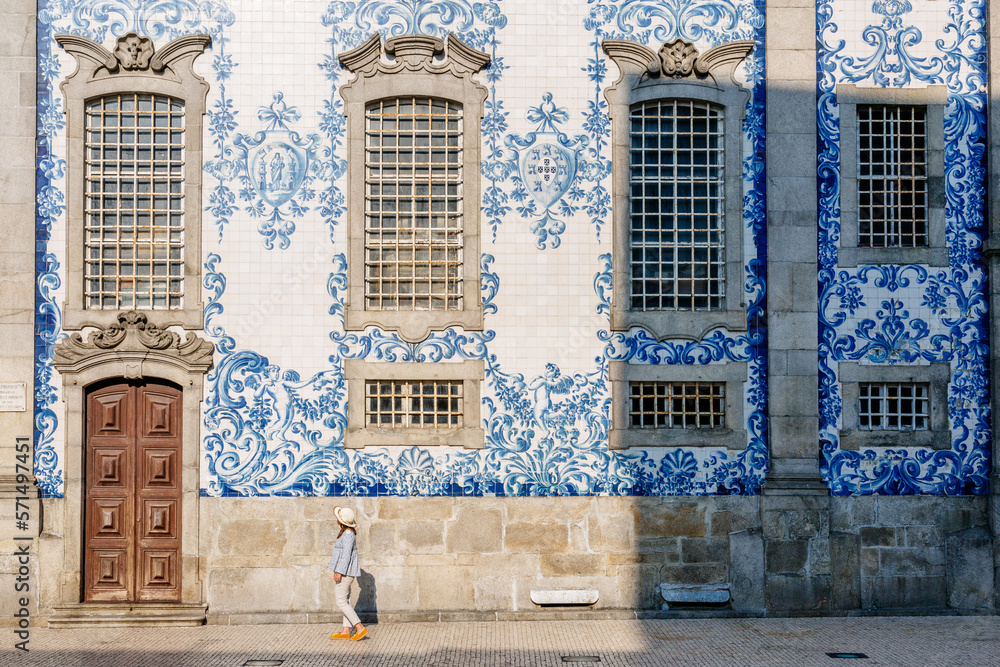 Wall mural tourist walking, azulejos tiles over chapel of souls, porto, portugal