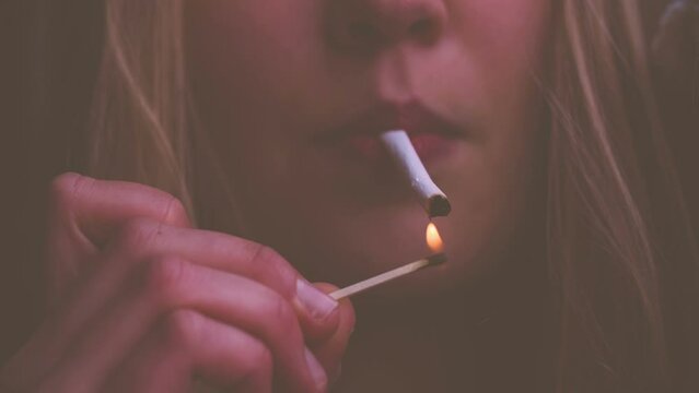 Close-up of woman lighting a cigarette in slow motion