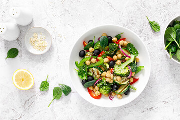 Chickpea and spinach vegan vegetable salad with broccoli, sweet pepper, olives and grilled...