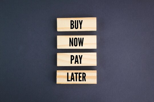 wooden arrangement with the words Buy Now Pay Later. business concept. first buy concept