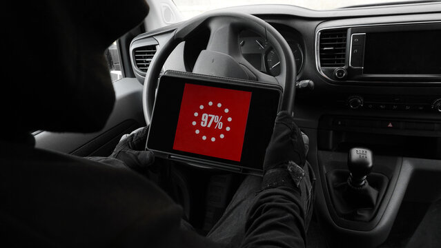 a person inside a car with a tablet in his hands, on which the alarm decontamination program is running  
