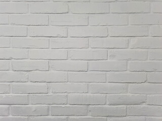 Brick wall painted with white paint. Regular brickwork. White brick background.