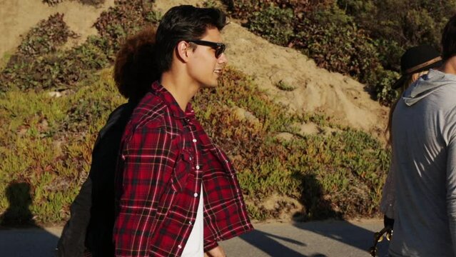 Friends walking along cement path at beach