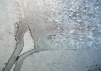 Glasscheibe mit Eismuster bei Schnee und Frost am Morgen im Winter