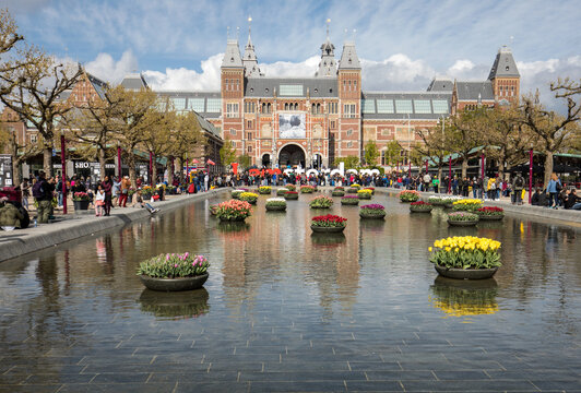 Rijksmuseum National Museum With I Amsterdam Sign And Tulips In The Reflecting Pool. Amsterdam, Netherlands