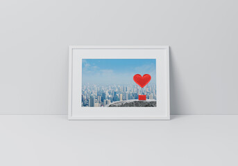 Red fabric heart love air balloon on rock mountain over city tower poster in horizontal white frame on floor over grey wall, Valentines day concept, 3D rendering